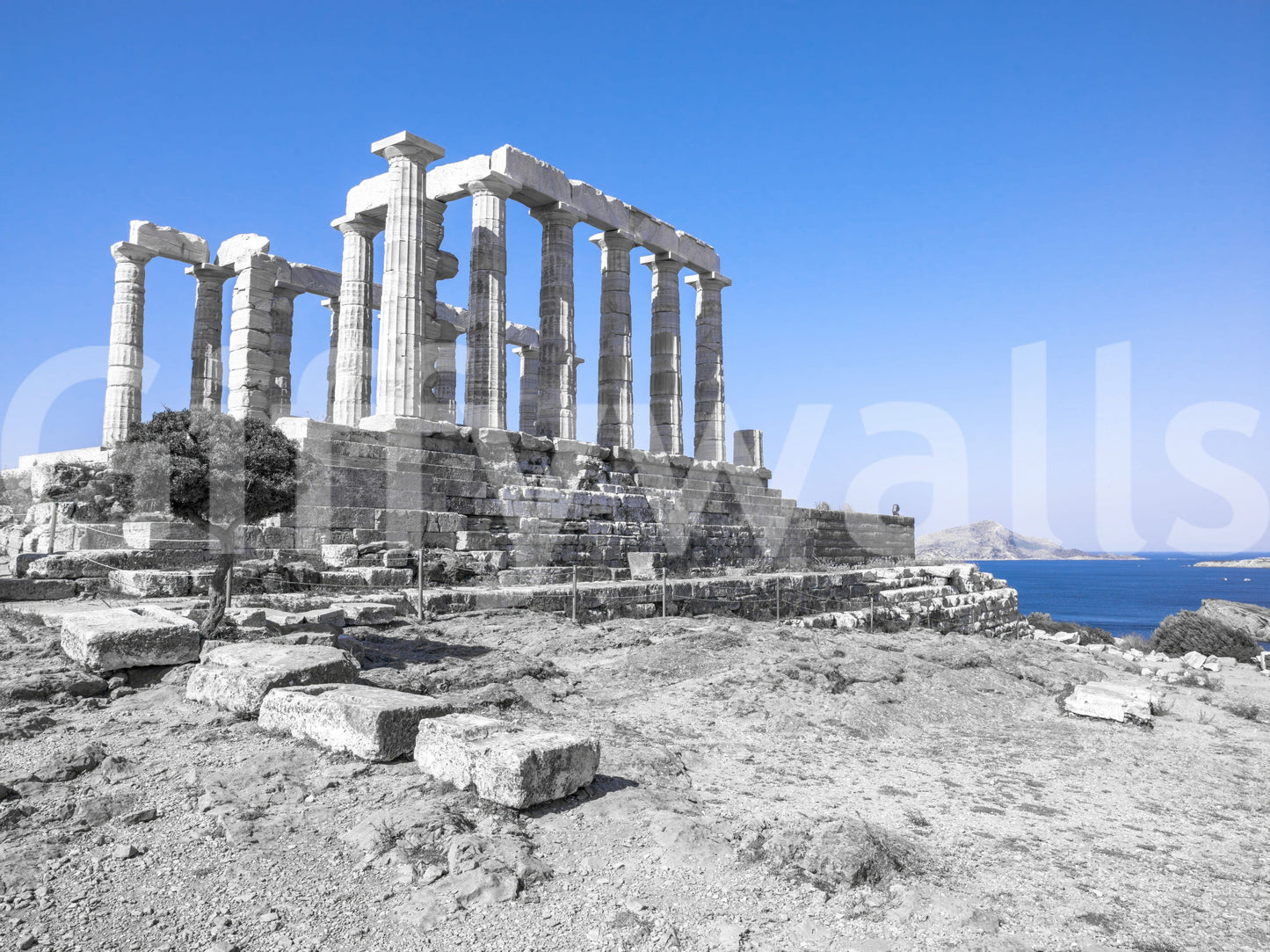 The wallpaper presents the ancient ruins of the Poseidon Temple contrasting beautifully with the vivid blue shoreline.