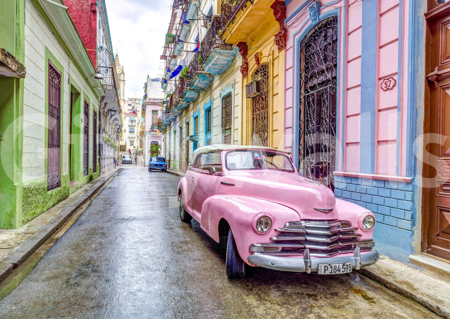 Pink car parked along vibrant colonial Havana street