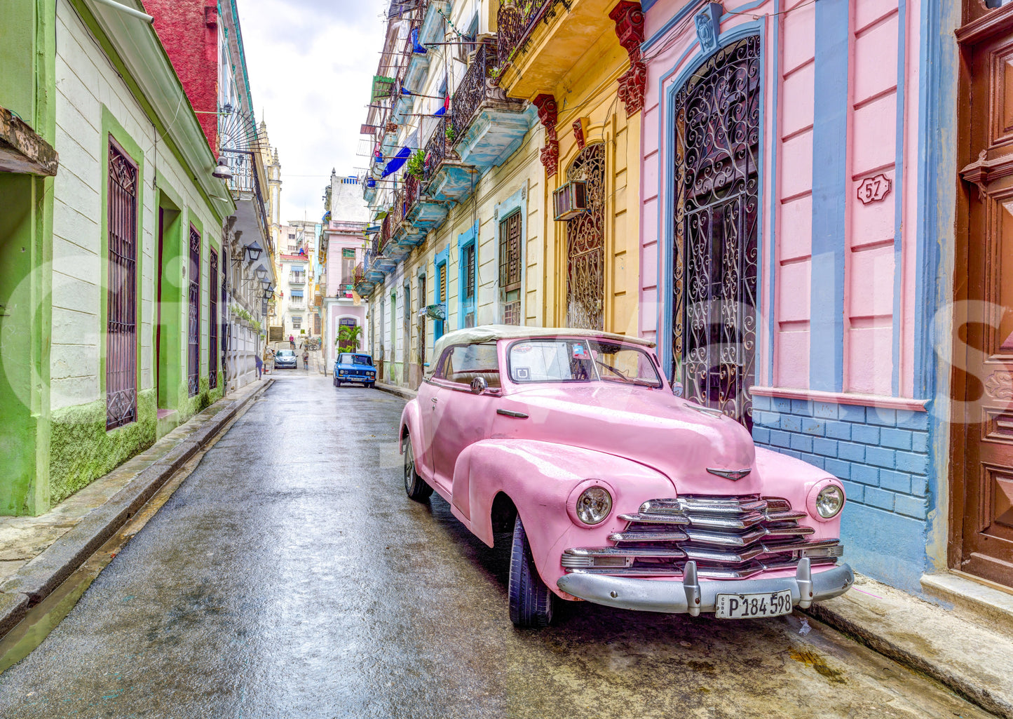 Pink car parked along vibrant colonial Havana street