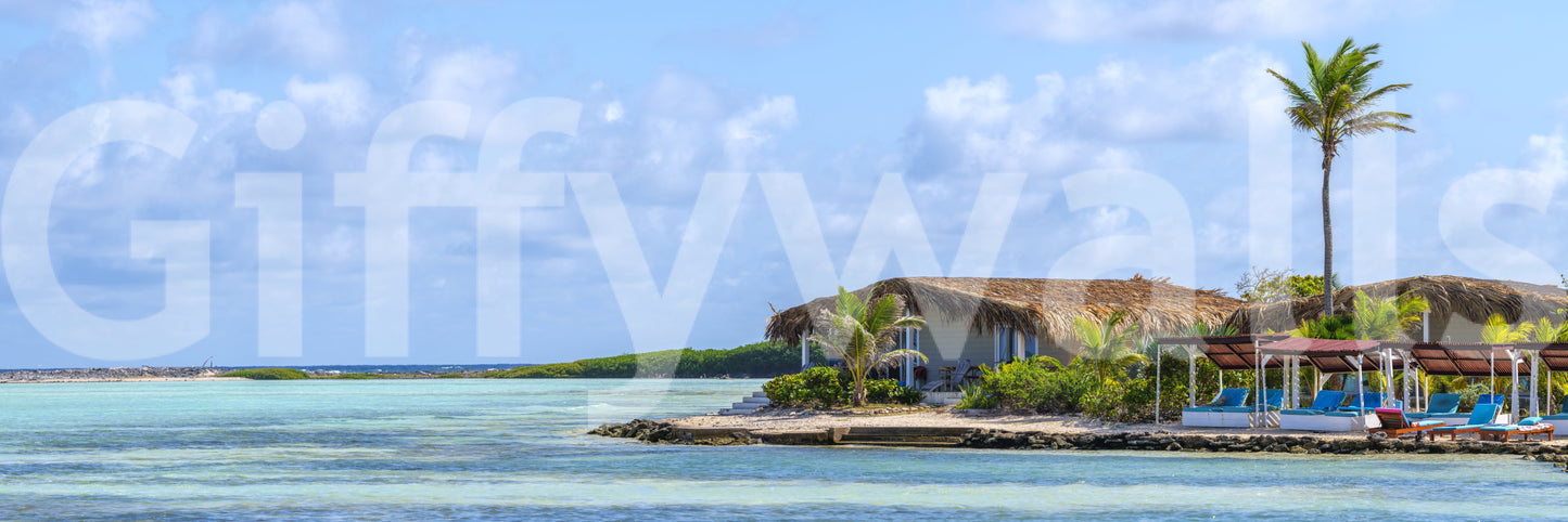 Beach scene with sun loungers under a shaded canopy.