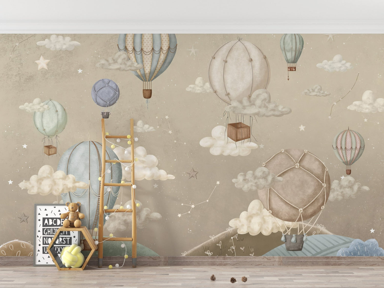 A child's playroom featuring a whimsical hot air balloon wallpaper with colorful balloons floating among clouds on an accent wall behind a white crib.