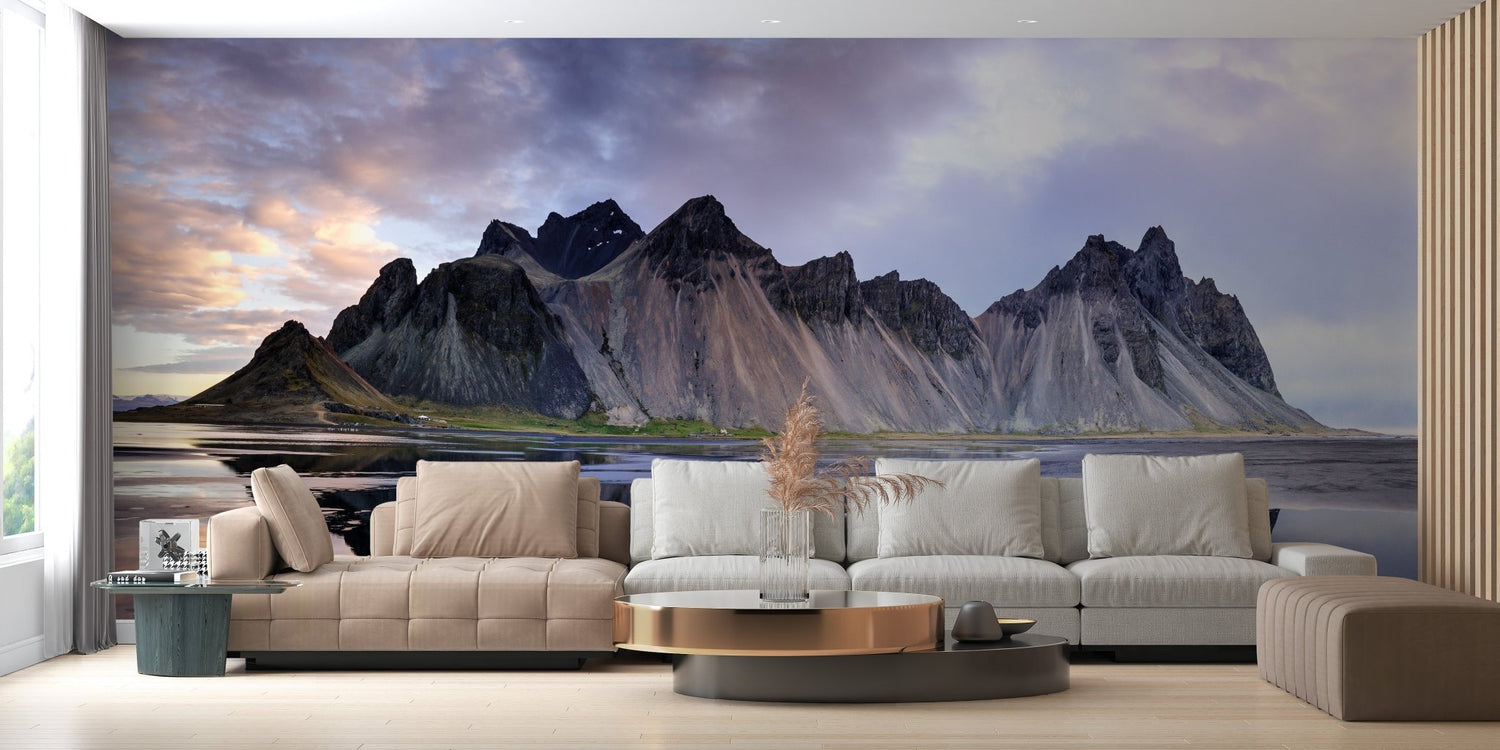 Mountain wallpaper murals installed behind a modern sofa, showing misty gray peaks at sunrise.