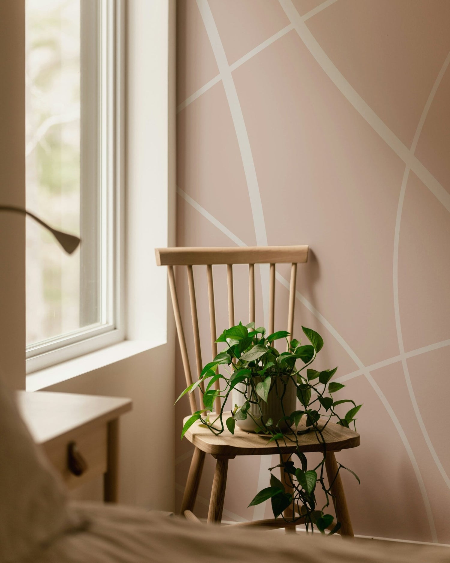 An eye-level shot of a modern living room featuring a geometric wallpaper by style accent wall.