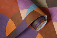 1970s Hex Dot Brown Color wallpaper rolled up, close-up showing bold circles and arcs in purple, rust and teal