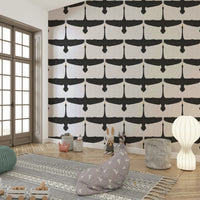 Swan silhouettes soaring across textured gray wallpaper

