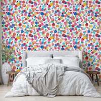 Cheerful polka dot mural in coral, teal, blush, and mustard tones.

