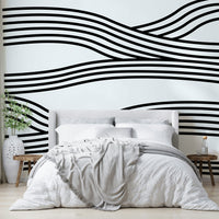 Black and white wave mural with rhythmic, flowing curves.


