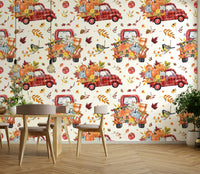 Features vintage-style pickup trucks, loaded with autumn harvest items like pumpkins, hay bales, and corn.
