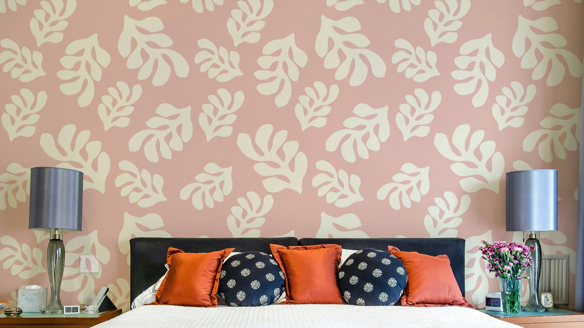 A photo-realistic wall mural with a repeating pattern of soft pink leaves.

