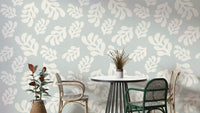 A photo-realistic wall mural with a repeating pattern of green leaves.


