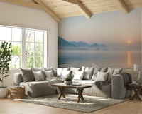 The foreground shows a peaceful field or forest half-hidden in the mist.
