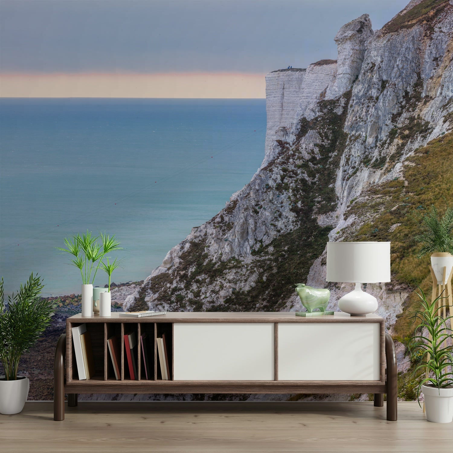 The image shows a calm ocean with majestic cliffs rising from the water.

