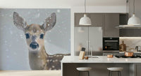 Whimsical winter wallpaper with a quiet fawn among snow-dusted trees and foliage.