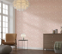 A minimalist blush wallpaper decorated with small blooming flowers for a serene spring look.