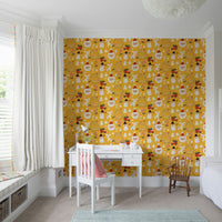 Cute Christmas motifs—including reindeer, cottages, and snowmen—create a joyful pattern on this yellow holiday wallpaper.