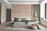 Mid-century inspired wallpaper with abstract pinwheel flowers in cream against a soft pink backdrop.