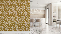 Mid-century inspired wallpaper with geometric pinwheel blooms in cream and warm golden tones.