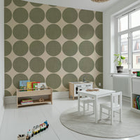 Beige wallpaper decorated with large olive dots that have a subtle fabric-like texture