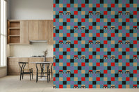 Colorful checkerboard wallpaper with playful peekaboo eyes hidden among red, cream, purple, black, and blue tiles.