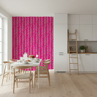 A retro wallpaper with repeating vine patterns and pastel leaves set on a bold fuchsia base.