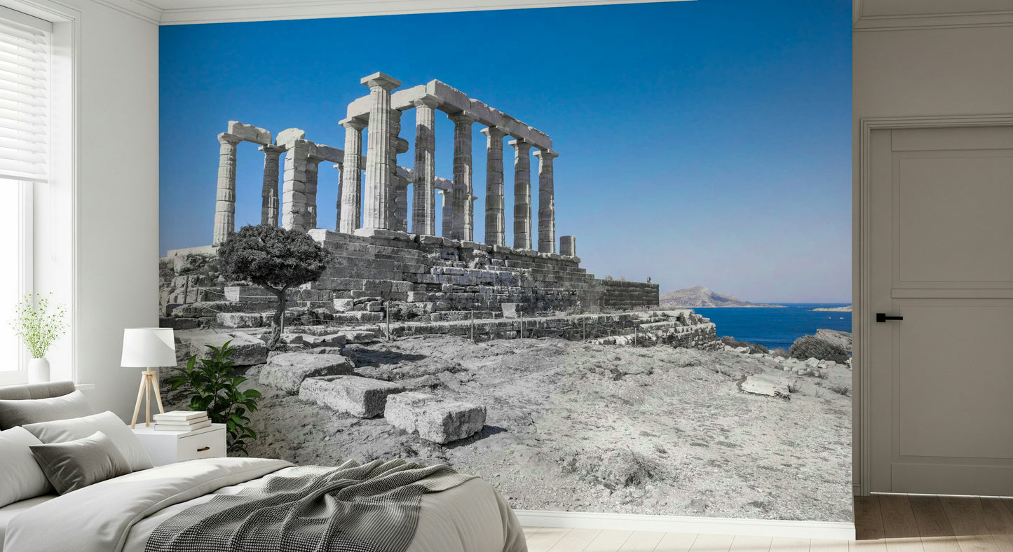 A dramatic wallpaper showing tall temple columns standing firmly atop a rocky landscape by the sea.