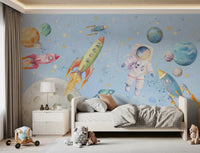 Watercolor astronaut wall mural with rockets flying across a pastel sky