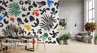 Dining area featuring Vibrant Shapes wall mural with tropical fronds and cutout motifs