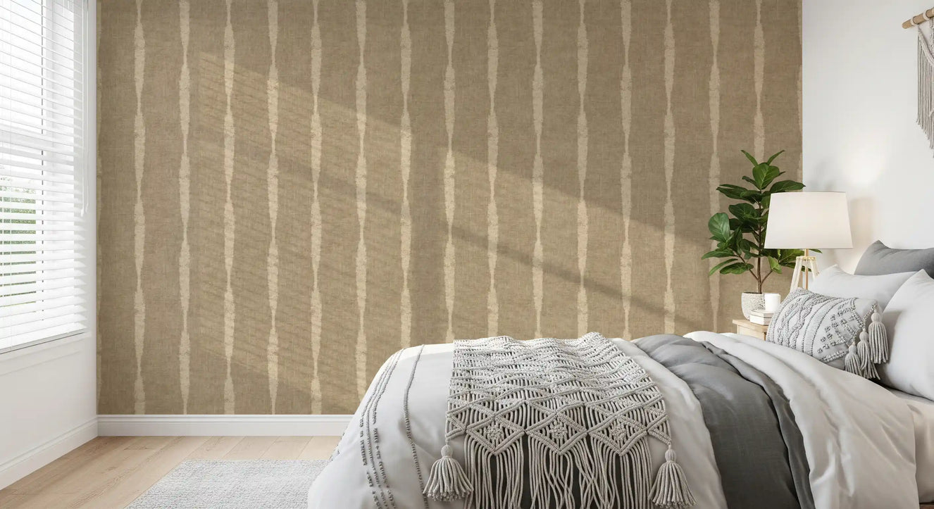 Warm beige stripes wallpaper frames a bedroom scene with quiet, earthy character.