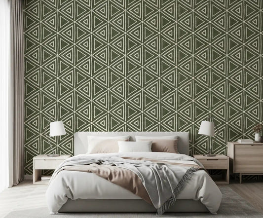 Moss green triangle wallpaper behind a calm bedroom in a boho, earthy scheme