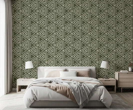 Moss green triangle wallpaper behind a calm bedroom in a boho, earthy scheme