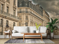 Stormy cloud cover hangs above the living room in this Parisian Facades wall mural.