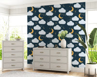Pattern repeat of clouds, moons and sparkles on this navy wallpaper