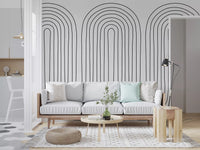 Living room backed by a quiet looping wall mural in cream and charcoal