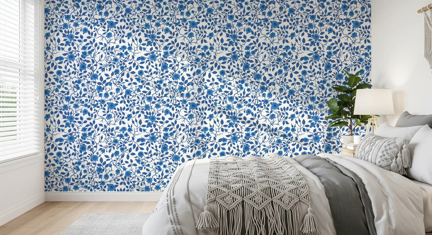 Indigo roses cluster along thorned stems in this Wild Blue and White wallpaper.