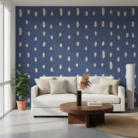 Cream droplets scatter over a dusty blue living room wall mural in mid-century mood.