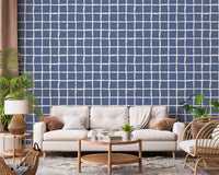 Dusty blue squares sit behind a calm living room in this wavy grid wallpaper.