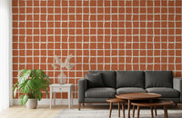 Slanted cream lines mark a rust-toned living room wallpaper with mid-century flair.