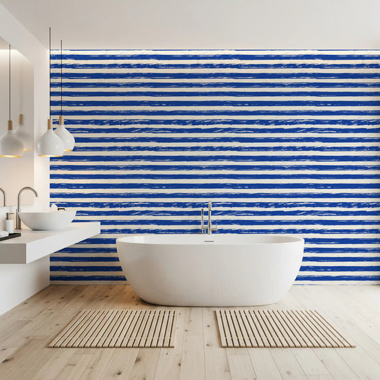 Coastal navy stripe wallpaper in a bathroom with a freestanding tub and wood floor GD12267