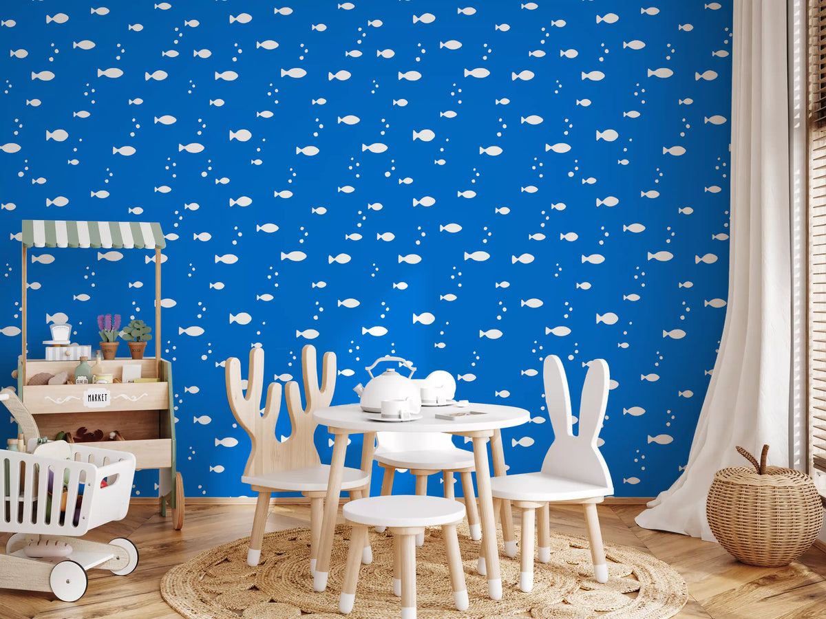 Aquatic blue print wallpaper in a kids playroom with white bunny chairs and a toy market stall GD12268