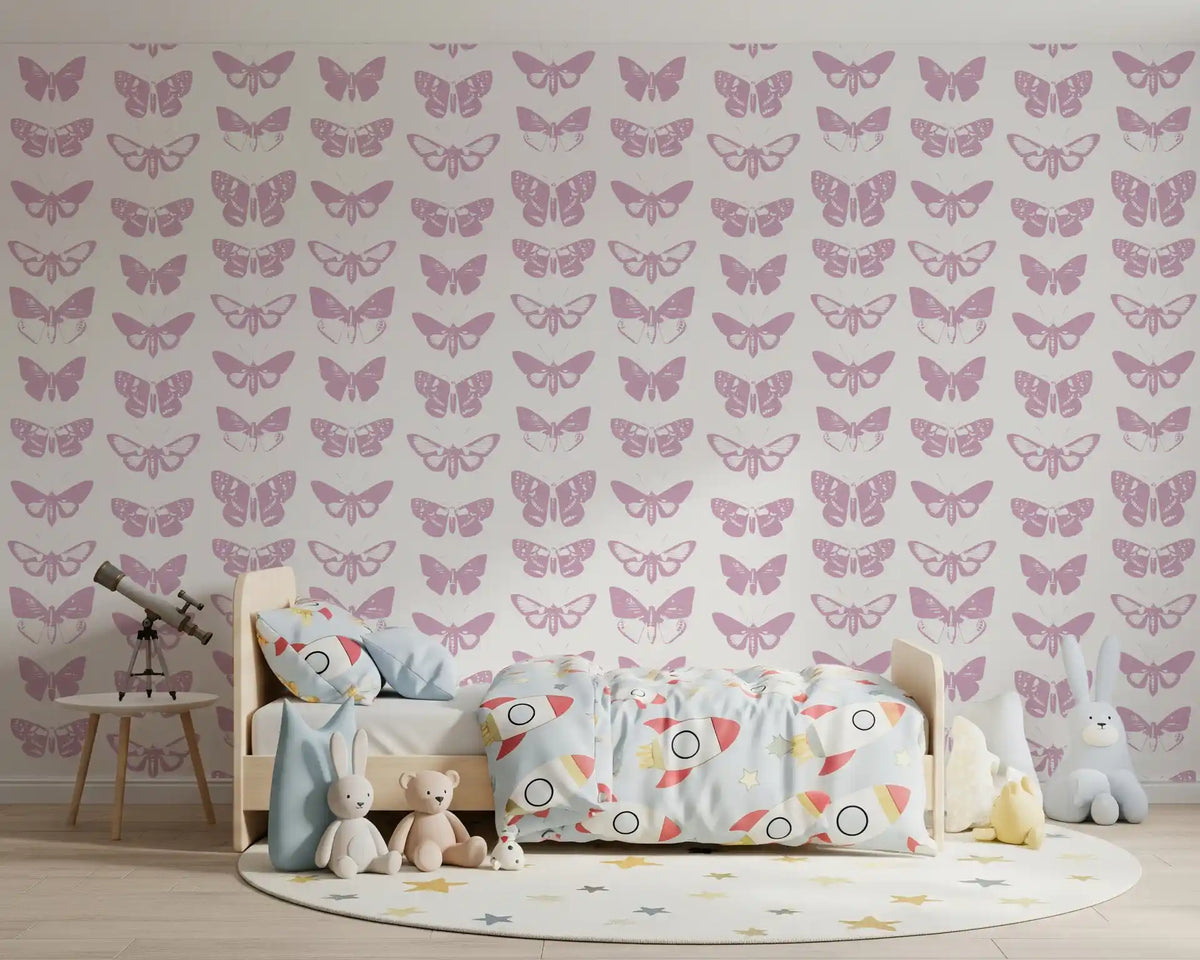 Soft pink moth assemblage wallpaper behind a toddler bed with a telescope and star rug GD12294