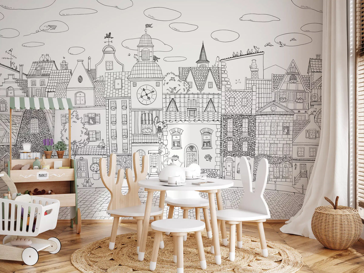 Cat cityscape wall mural behind a play table with bunny-ear chairs and a white crib GD12396