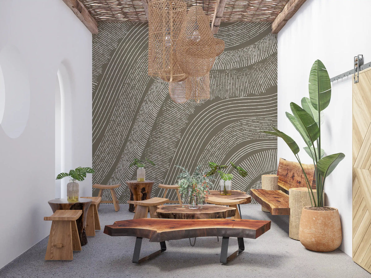 Taupe wavy etched lines mural in a boho lounge with live-edge wood tables and plants GD12471