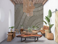 Taupe wavy etched lines mural in a boho lounge with live-edge wood tables and plants GD12471
