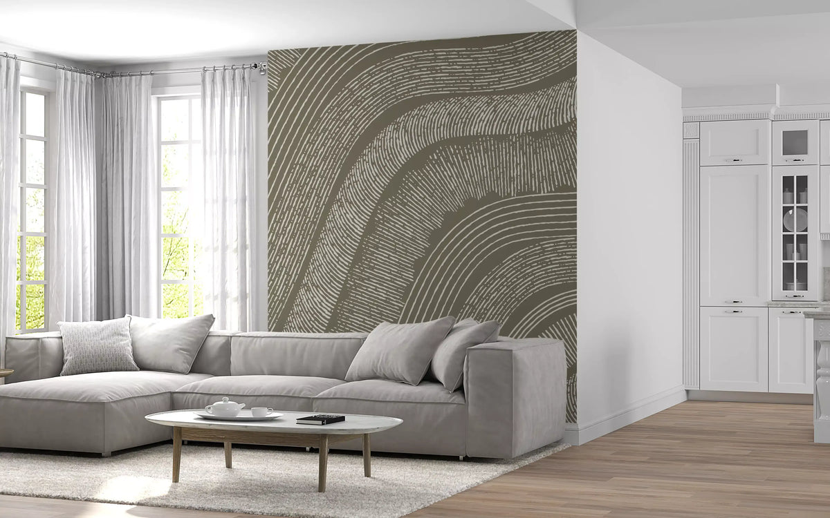 Taupe wavy etched lines mural behind a grey sectional sofa by a bright bay window GD12471