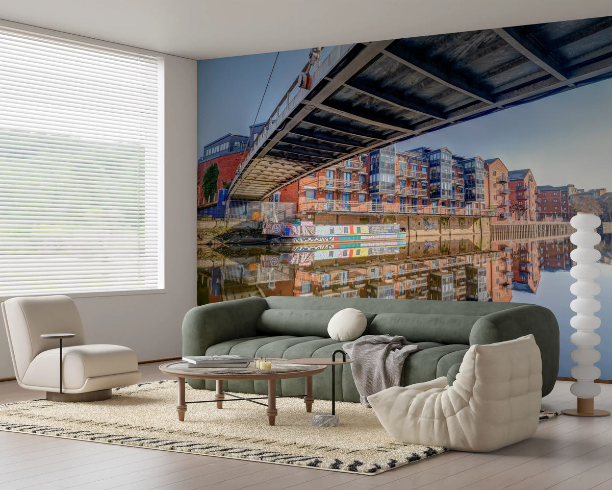 Steel bridge wall mural behind a green sofa and grey pouf in an open living room GD12837