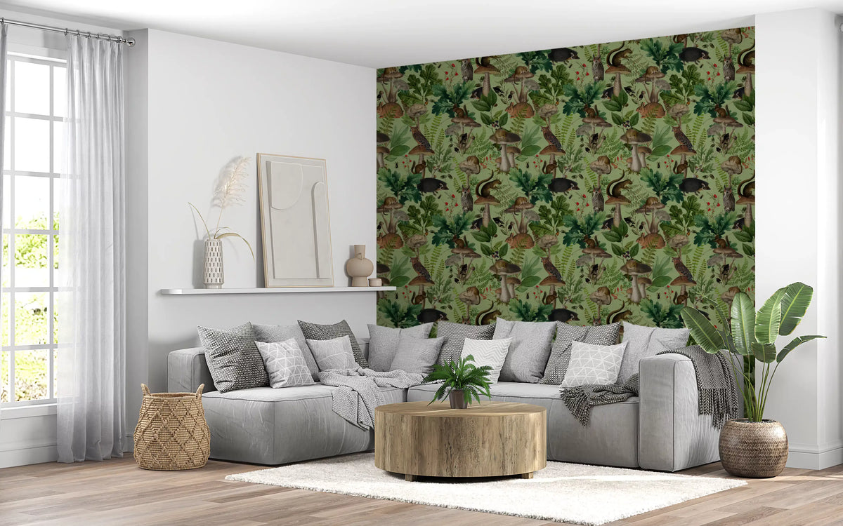 Sage green woodland wallpaper behind a grey sectional in a living room (GD12999)