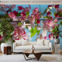 Panorama mural de branches fleuries roses sur fond bleu ciel