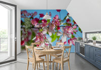 Panorama mural de branches fleuries roses sur fond bleu ciel