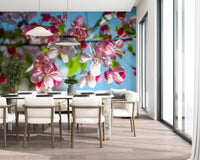 Panorama mural de branches fleuries roses sur fond bleu ciel