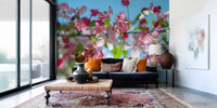 Panorama mural de branches fleuries roses sur fond bleu ciel